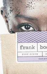 Girl holding coffee scrub packet up to face