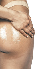 woman applying coconut body balm onto bottom