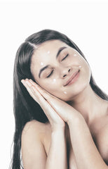 Girl with creamy face scrub on face and biting tube