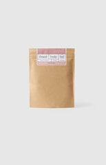 Girl holding coffee scrub packet up to face